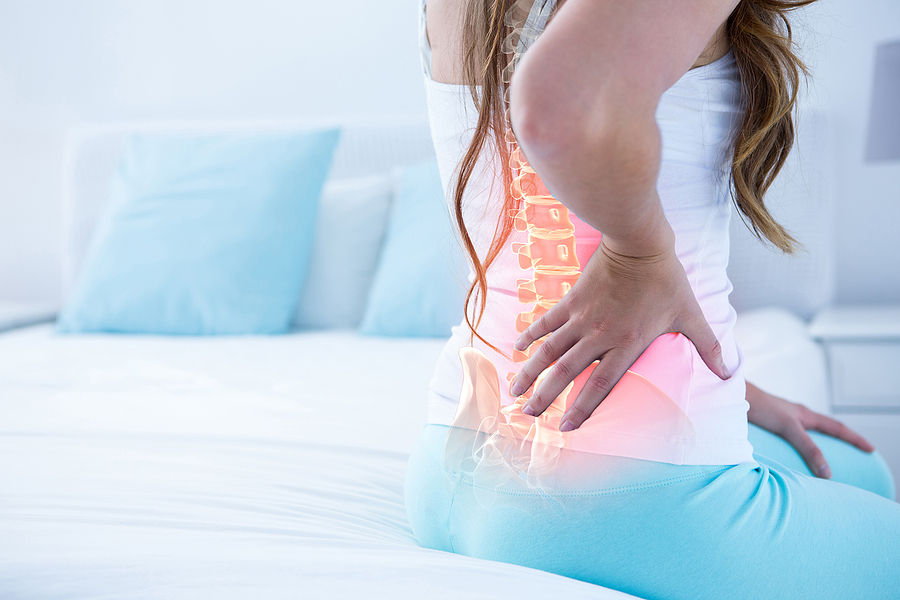 Person with lower back pain highlighting the spine, illustrating ankylosing spondylitis symptoms and spinal inflammation.